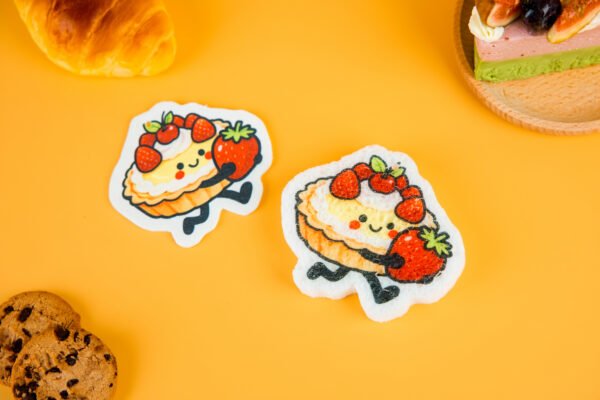 Bakery Friends â Strawberry Tart Biodegradable Sponge | Doyourclean Strawberry tart-shaped cellulose sponges on yellow surface with bread and cookie props.