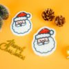 Christmas Friends â Santa Claus Eco Sponge | Doyourclean Santa Claus-shaped cellulose sponges on Christmas setup with pinecones and ornaments.