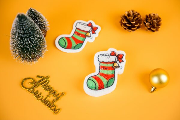 Christmas Friends â Christmas Stockings Eco Sponge | Doyourclean stocking-shaped cellulose sponges from Doyourclean Christmas Friends collection on yellow background with Christmas ornaments.