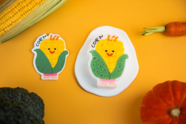 Vegetable Friends â Corn Eco Sponge | Biodegradable Kitchen Cleaning Corn-shaped cellulose sponge from Doyourcleanâs Vegetable Friends series placed on yellow background.