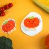 Vegetable Friends â Tomato Biodegradable Sponge | Doyourclean Single tomato-shaped cellulose sponge with a smiling face on a yellow backdrop.
