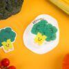 Vegetable Friends â Broccoli Eco Sponge | Doyourclean Single broccoli-shaped cellulose sponge on a yellow background, Vegetable Friends series.