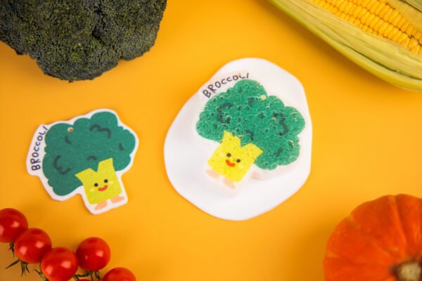 Vegetable Friends â Broccoli Eco Sponge | Doyourclean Single broccoli-shaped cellulose sponge on a yellow background, Vegetable Friends series.