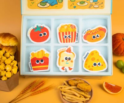 Another angle of Doyourclean Tasty Friends cellulose sponge set with yellow background and popcorn props.