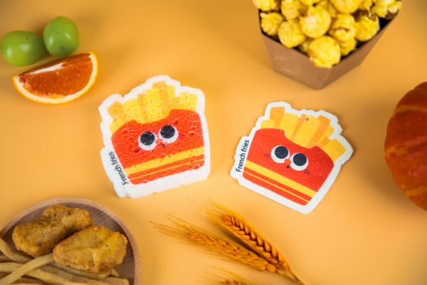 Tasty Friends â French Fries Sponge | Cute Eco Kitchen Sponge Two french-fries cellulose sponges from Doyourcleanâs Tasty Friends collection on a warm yellow backdrop with snack props.