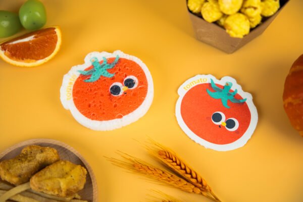 Tasty Friends â Tomato Sponge | Eco-Friendly Cleaning Set Two red tomato-shaped cellulose sponges by Doyourclean with smiling faces.