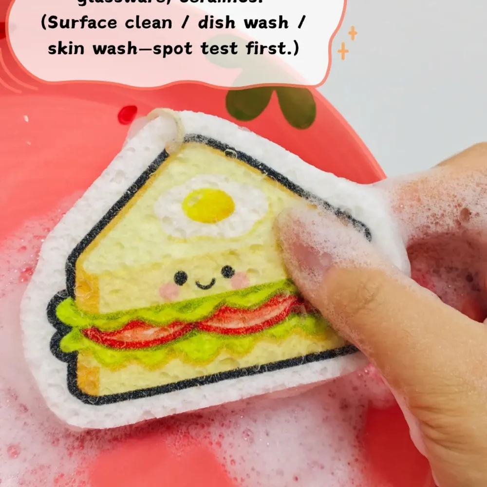 Sandwich-shaped cellulose sponge being used for dishwashing with foam and water.