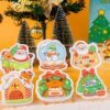 Santa Friends â Christmas Gift Sponge Box | Eco Holiday Cleaning Set A set of Doyourclean Santa Friends cellulose sponges featuring Santa, reindeer, sleigh, and candy house, arranged with Christmas decorations and snow props.