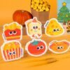 Tasty Friends â Fun Food Sponge Set | Cute Eco Dish Sponges A colorful arrangement of Doyourcleanâs Tasty Friends cellulose sponges shaped like fries, tomato, toast, and popcorn on a warm yellow background.
