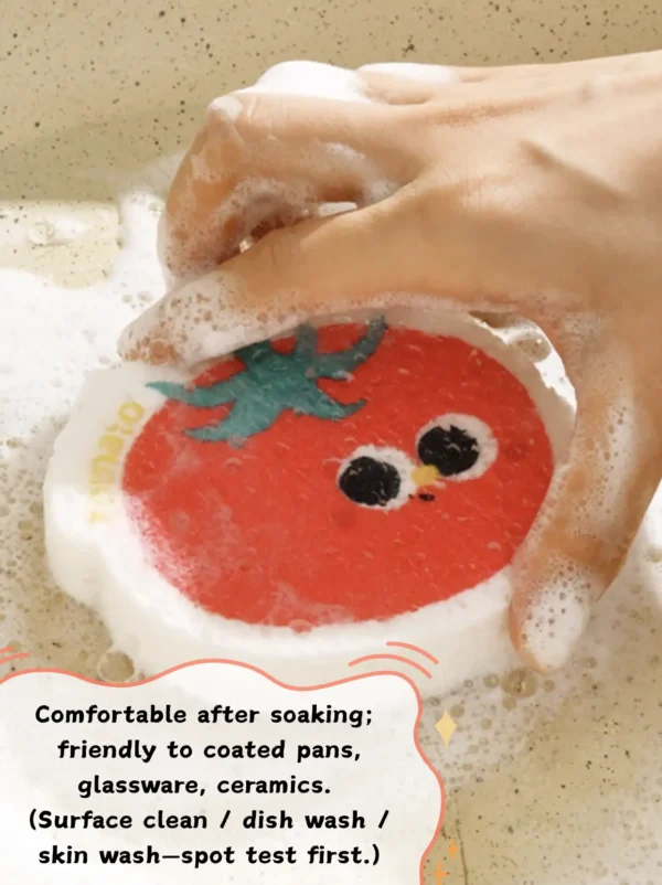 Tomato-shaped cellulose sponge creating rich foam while washing dishes